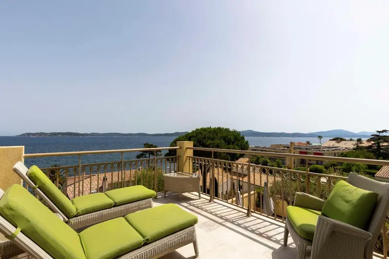 Terrasse avec mobilier d'extérieur et vue sur la mer.