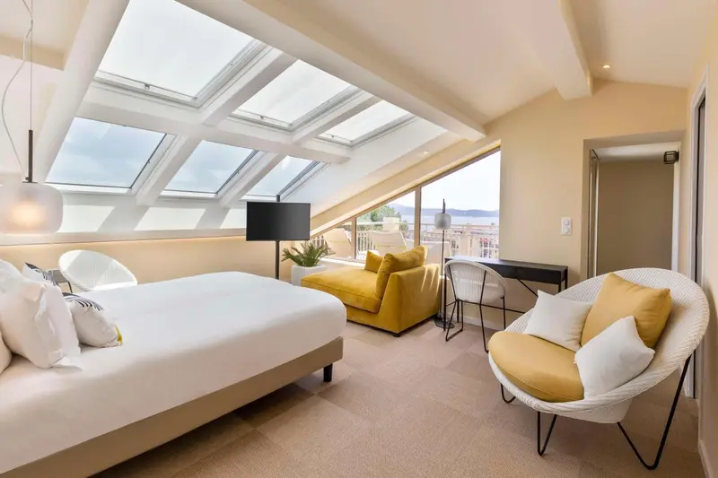 Une chambre lumineuse avec un lit et un coin salon.