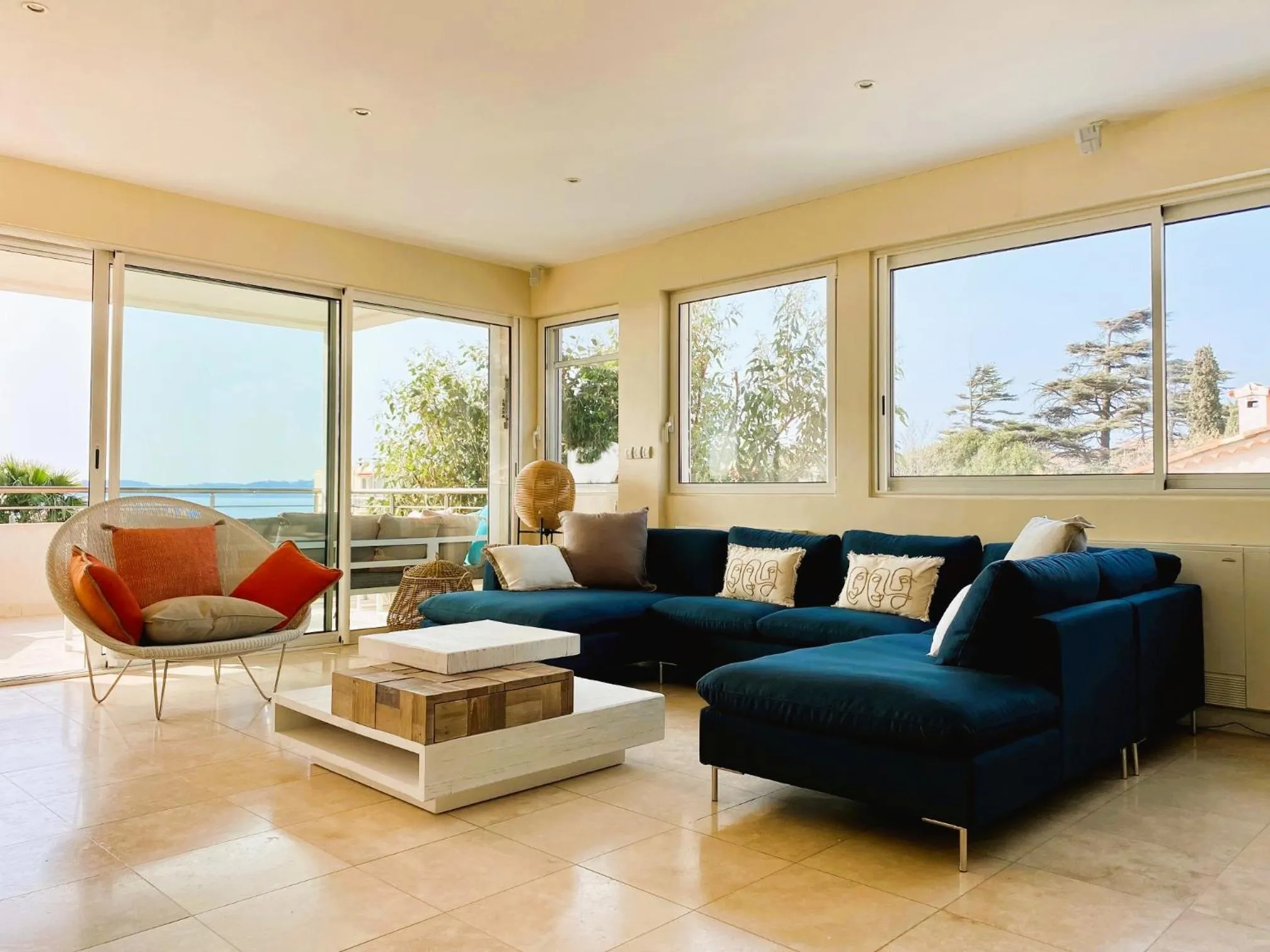 Espace de détente intérieur avec canapés et vue sur la mer.