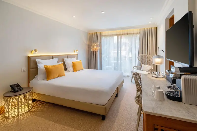 Une chambre lumineuse avec un grand lit et un coin salon.