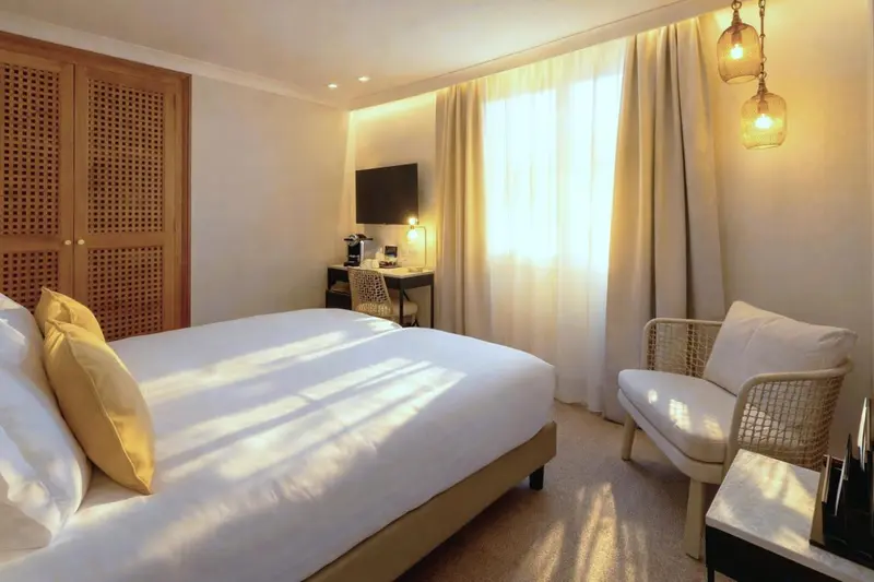 Une chambre lumineuse avec un lit confortable et un coin salon.