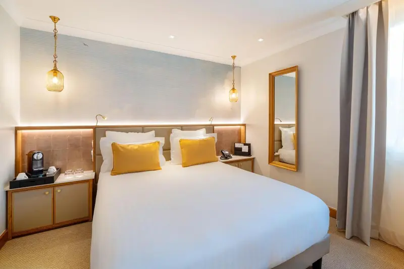 Une chambre lumineuse avec un grand lit et des oreillers colorés.