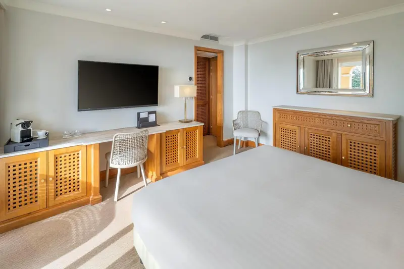 Une chambre lumineuse avec un grand lit et un bureau.