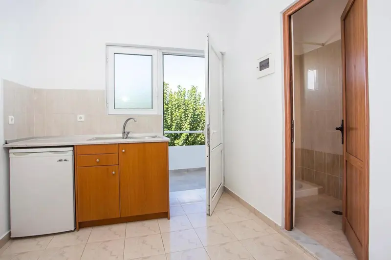 Une kitchenette lumineuse s'ouvre sur une salle de bain.