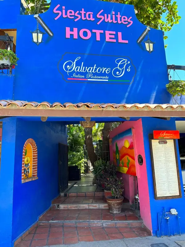 Entrée d'un hôtel coloré avec un restaurant attenant.