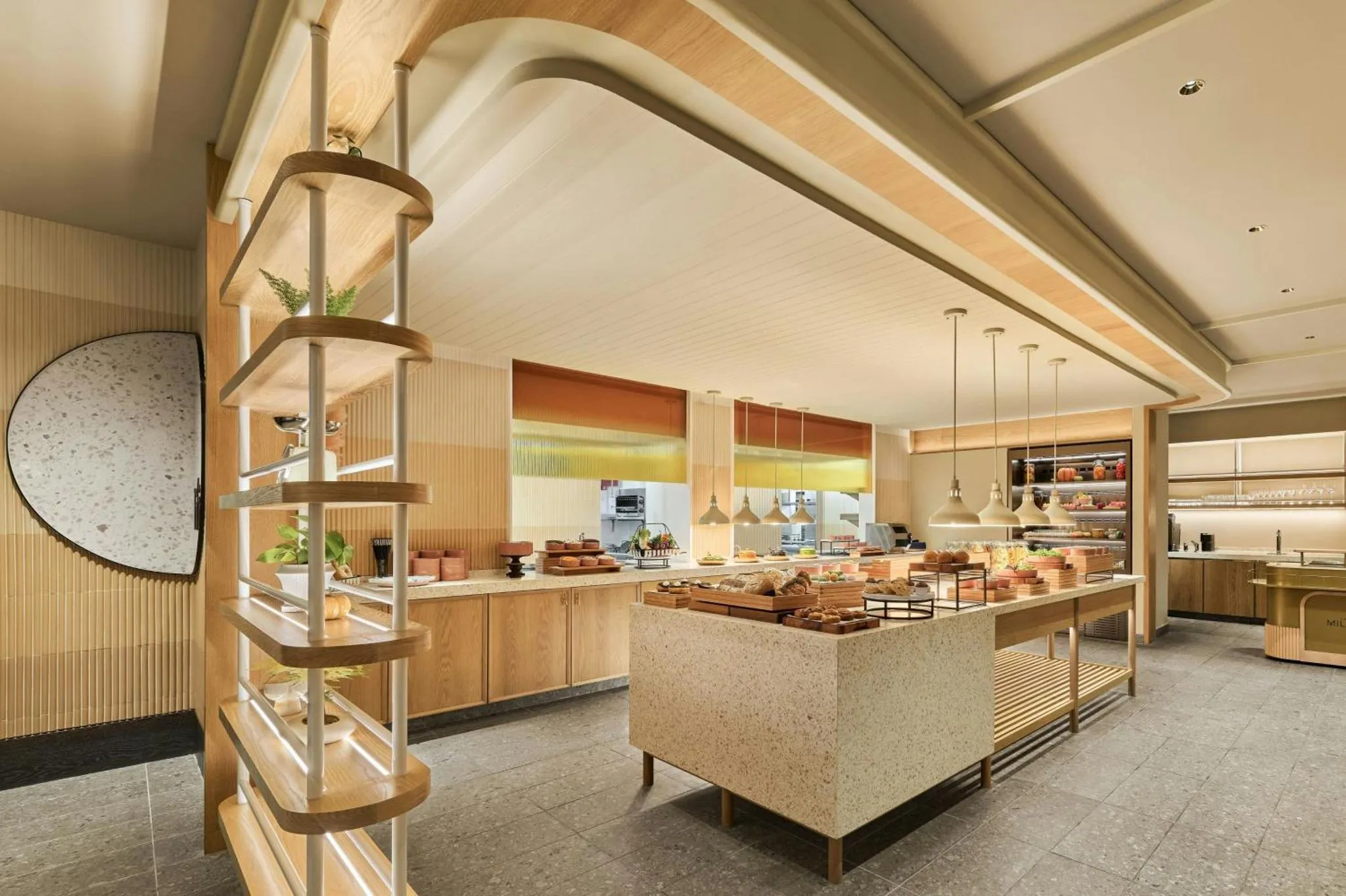 Un buffet propose une variété de plats et de pâtisseries dans un espace lumineux et moderne.