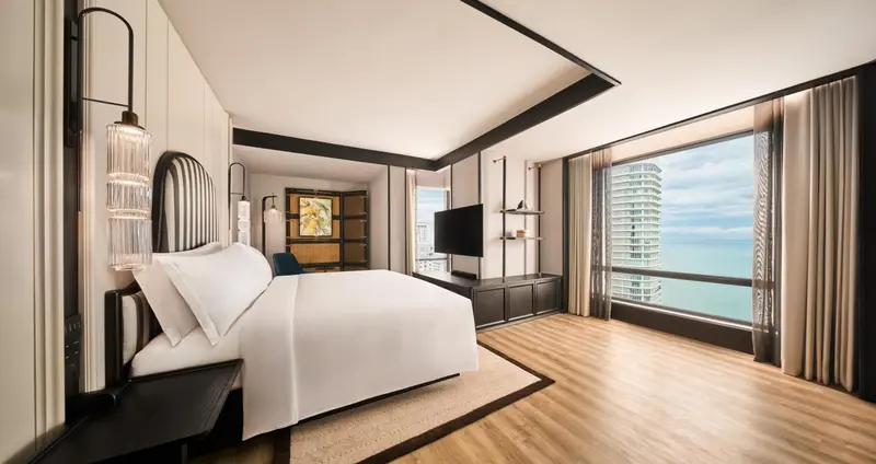 Une chambre lumineuse avec un grand lit et une vue sur la mer.