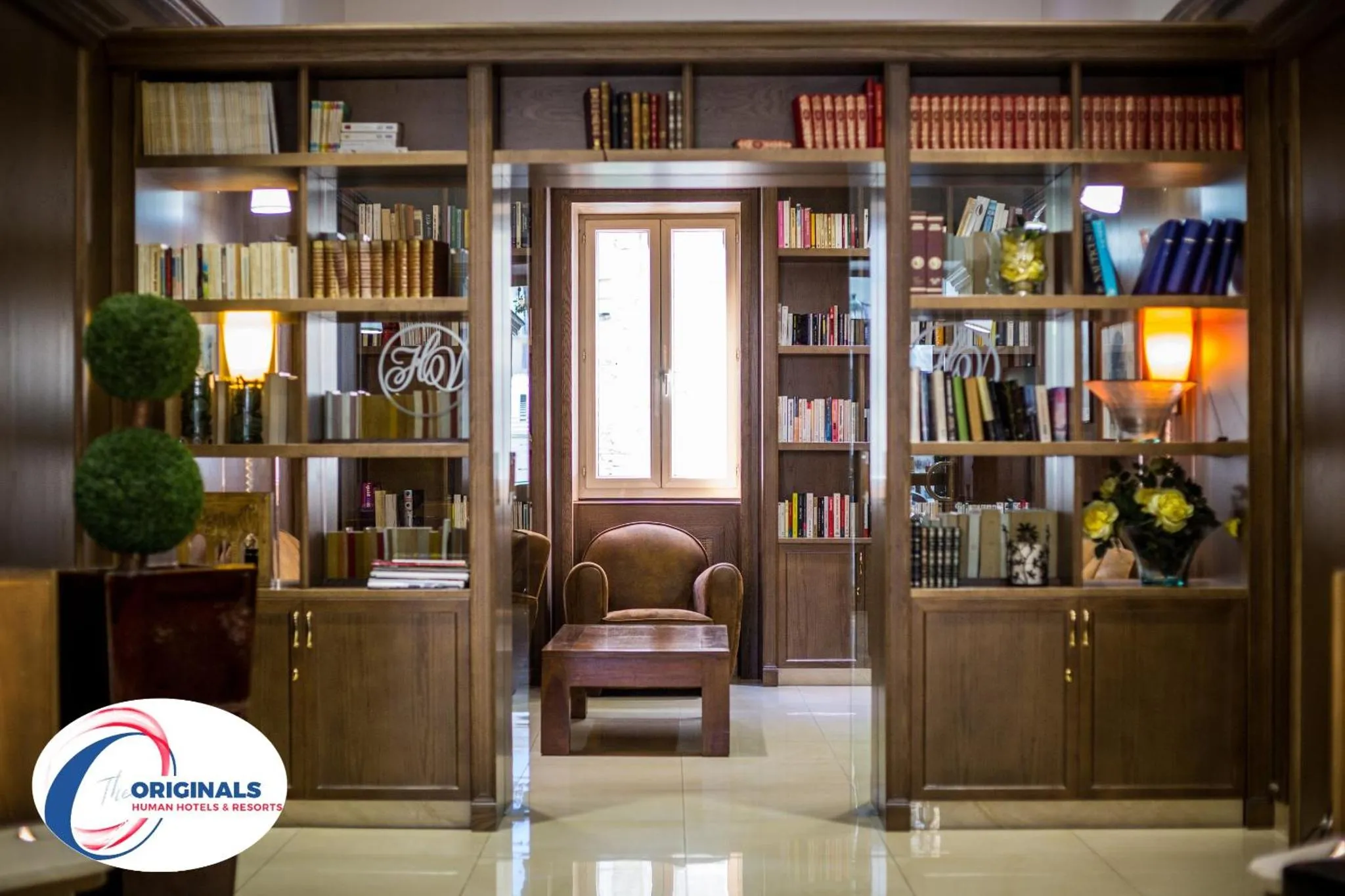 Bibliothèque aménagée dans un espace de détente avec des fauteuils et des étagères remplies de livres.