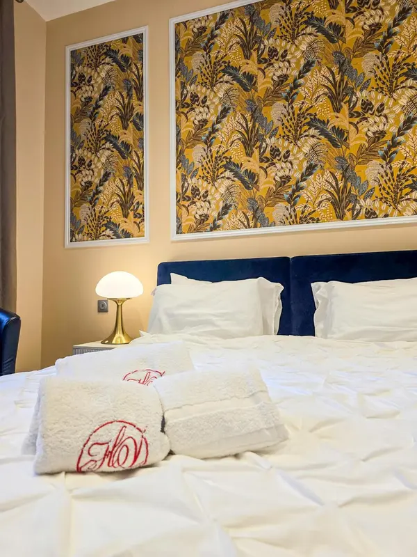 Un lit est fait dans une chambre décorée de motifs floraux.