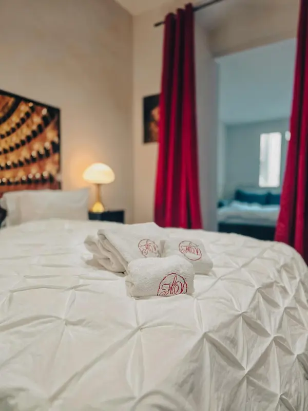 Un lit soigneusement fait avec des oreillers et des serviettes.