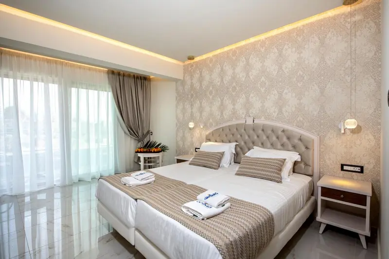 Une chambre lumineuse avec un grand lit et des rideaux blancs.