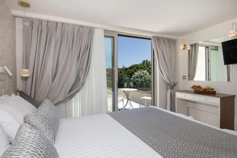 Une chambre lumineuse avec un grand lit et une vue sur une terrasse.