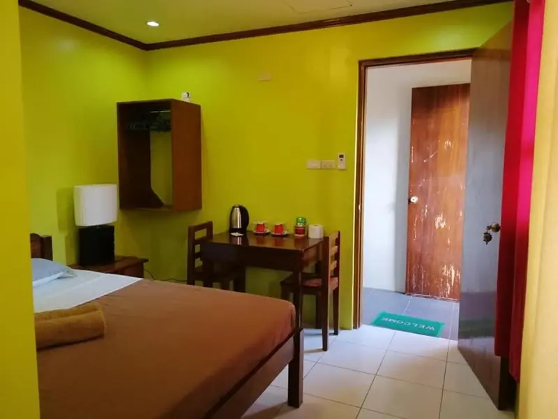 Une chambre avec un lit, une table et une commode.