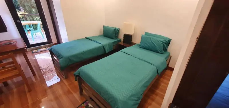 Une chambre avec deux lits simples et une vue sur l'extérieur.