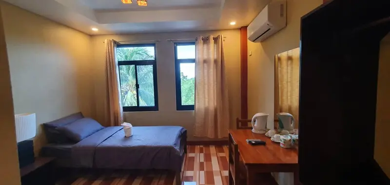 Une chambre lumineuse avec un lit et une table de chevet.