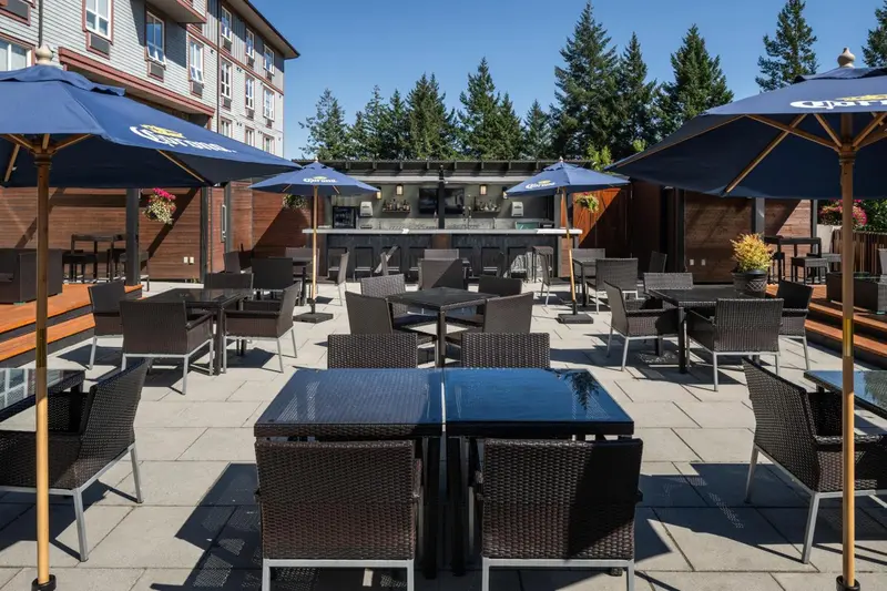 Terrasse aménagée avec tables et parasols devant un bâtiment.