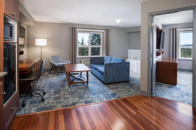 Espace de vie intérieur avec canapé, fauteuil et bureau.