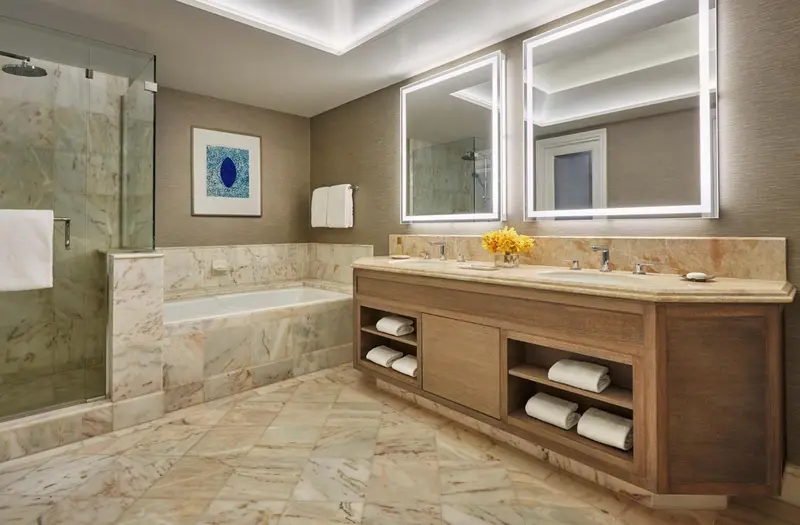 Une salle de bain spacieuse avec une baignoire et deux vasques.