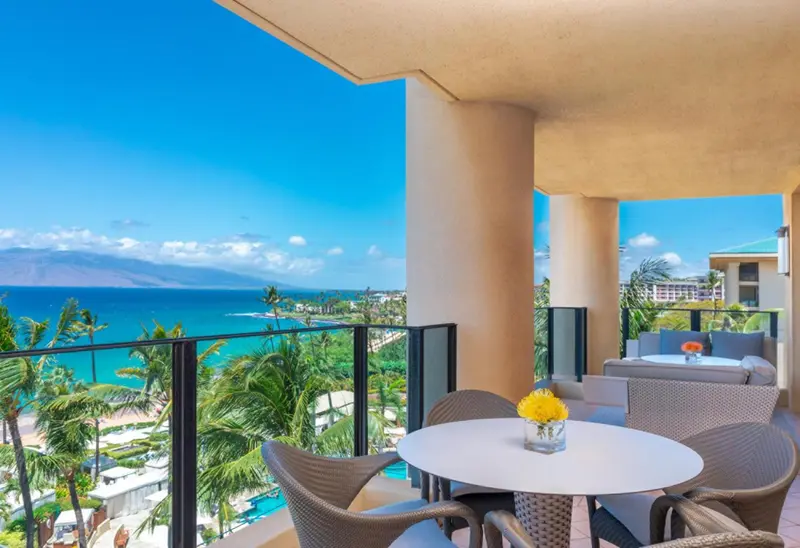 Vue sur la mer depuis une terrasse aménagée avec un coin repas et un espace détente.