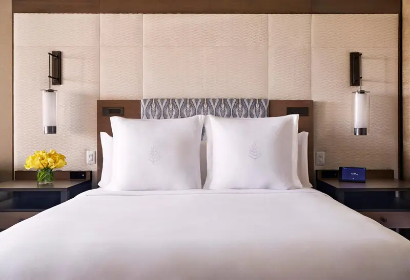 Un lit blanc avec des oreillers dans une chambre d'hôtel.