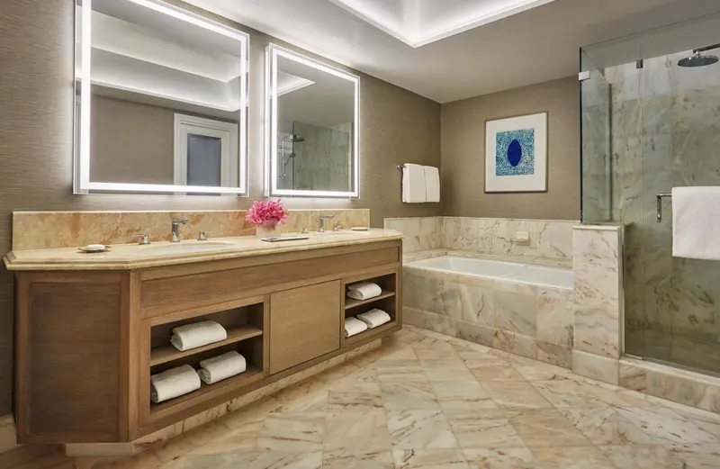 Une salle de bain lumineuse avec une double vasque et une baignoire.