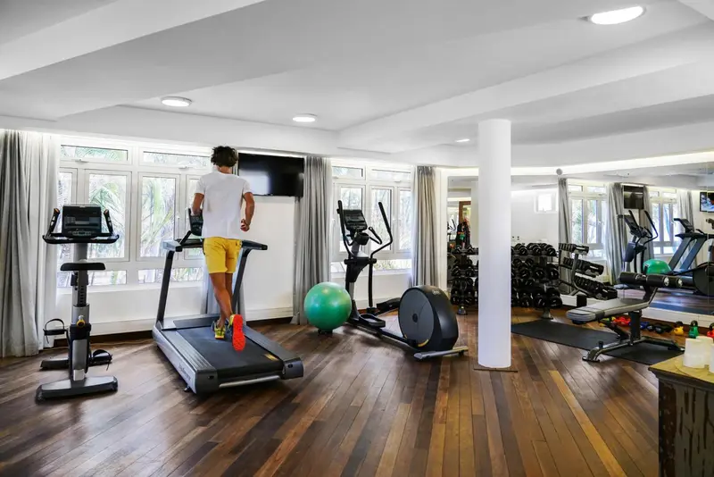 Une salle de sport lumineuse avec plusieurs appareils de fitness.