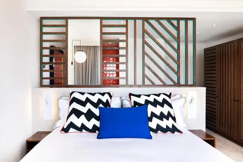 Un lit avec des oreillers décoratifs dans une chambre moderne.