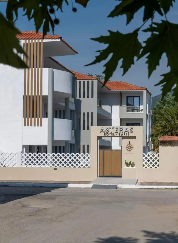 Façade d'un bâtiment blanc avec des éléments décoratifs en bois et une entrée.