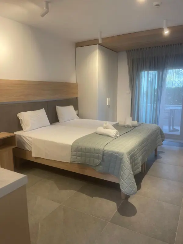 Une chambre lumineuse avec un grand lit et un accès à une terrasse.