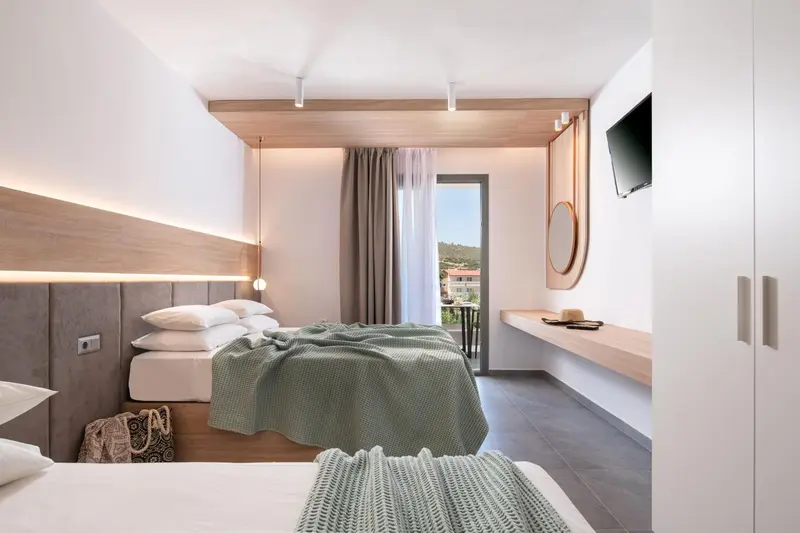 Une chambre lumineuse avec un grand lit et une vue sur l'extérieur.