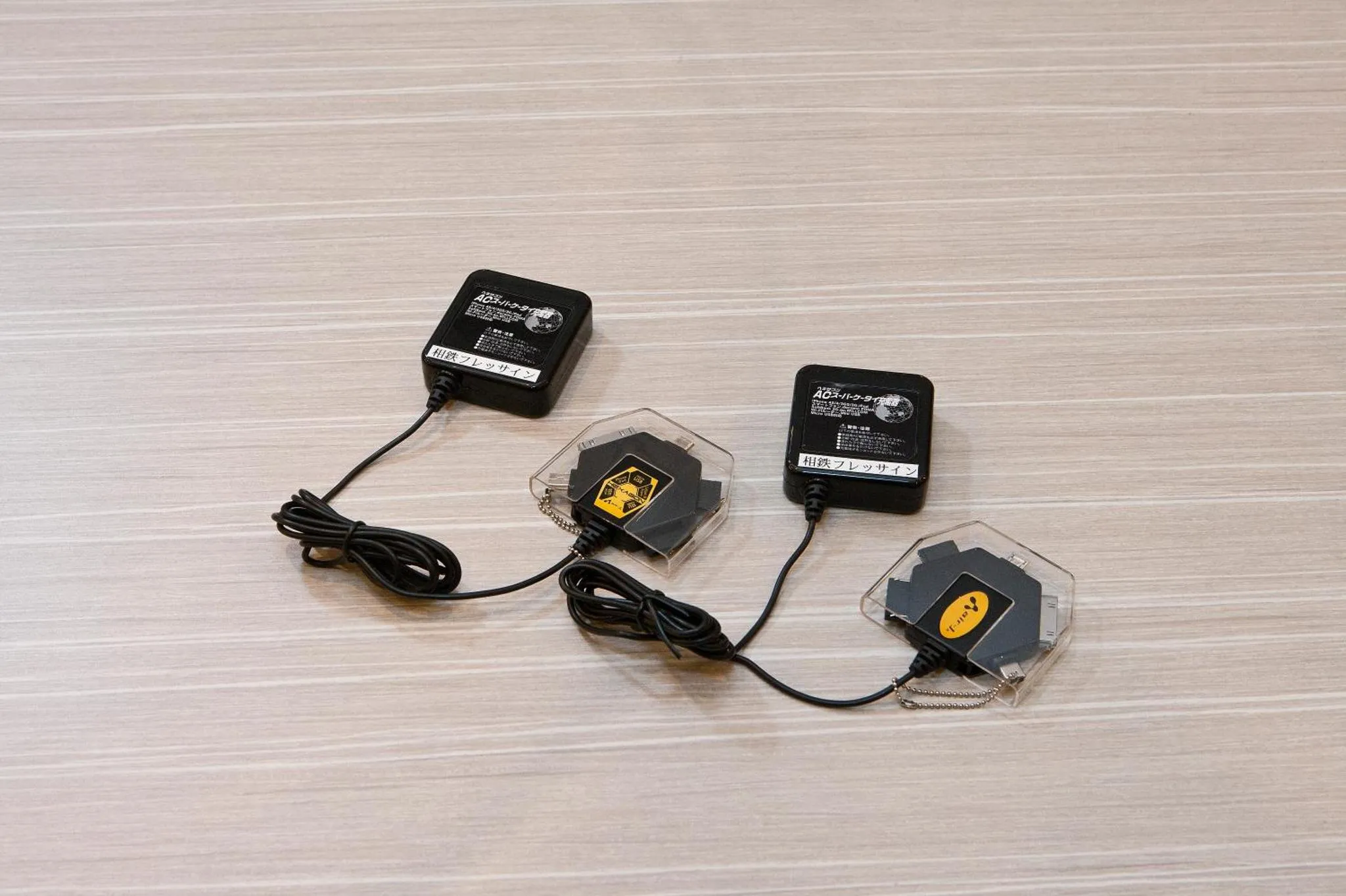 Plusieurs appareils électroniques noirs et gris reposent sur une surface en bois clair.