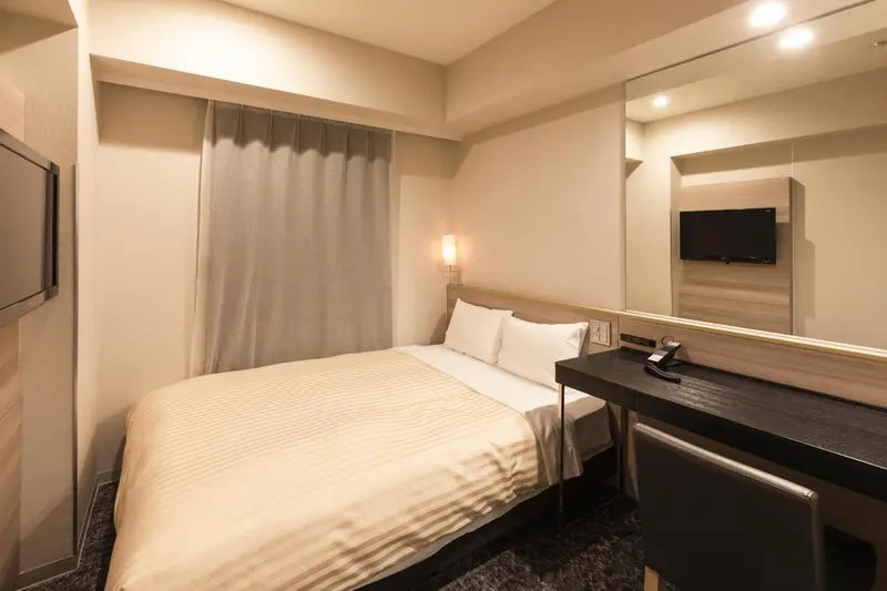 Une chambre d'hôtel avec un lit double et un bureau.