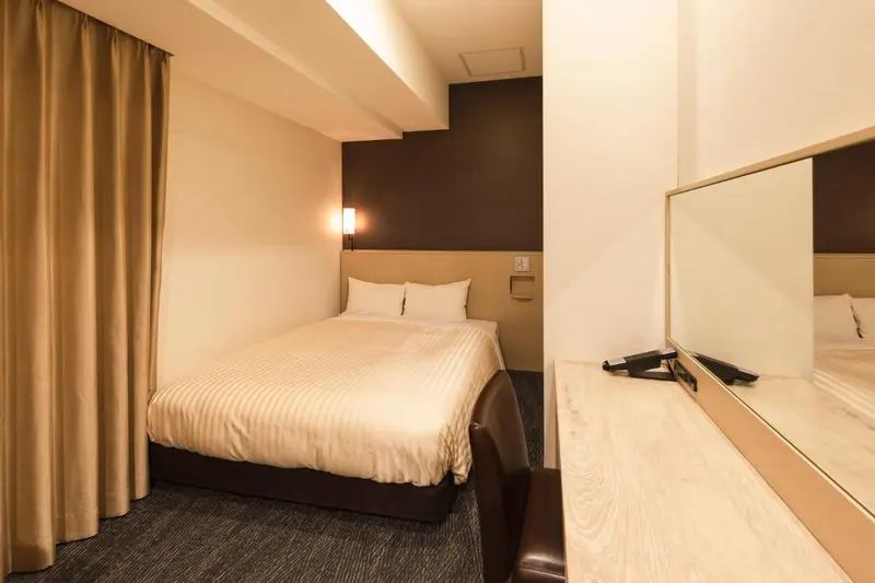 Une chambre d'hôtel avec un lit double et un bureau.