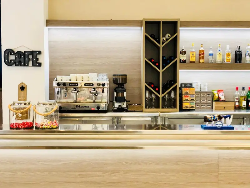 Un comptoir de bar présente des machines à café et des bouteilles.