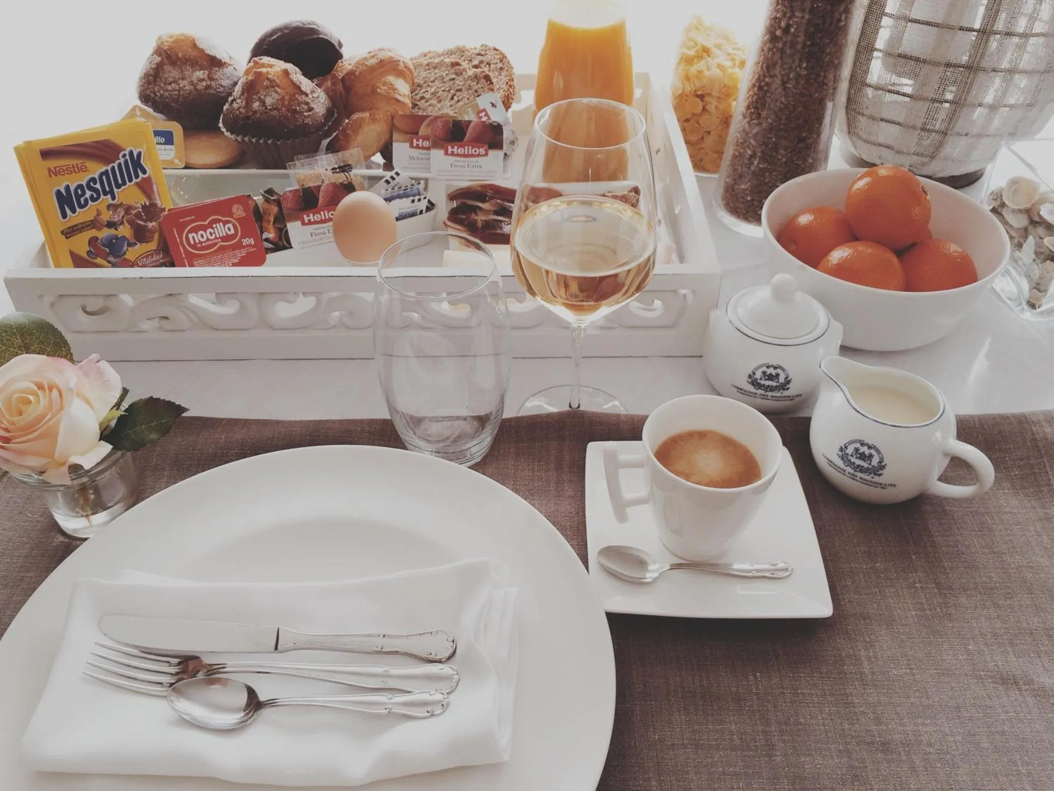 Un plateau de petit-déjeuner avec des viennoiseries, des fruits et des boissons est présenté sur une table.