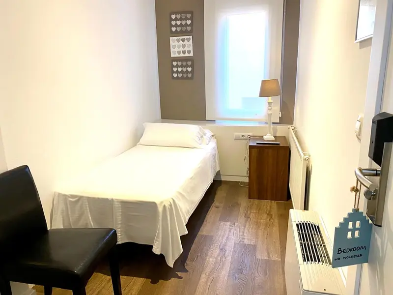 Une chambre simple avec un lit et une commode en bois.