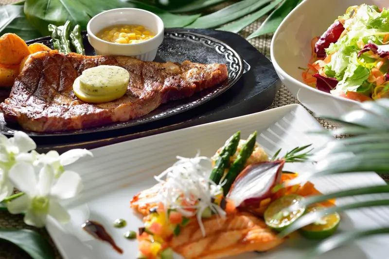 Assiette de viande grillée accompagnée de légumes et de salade.