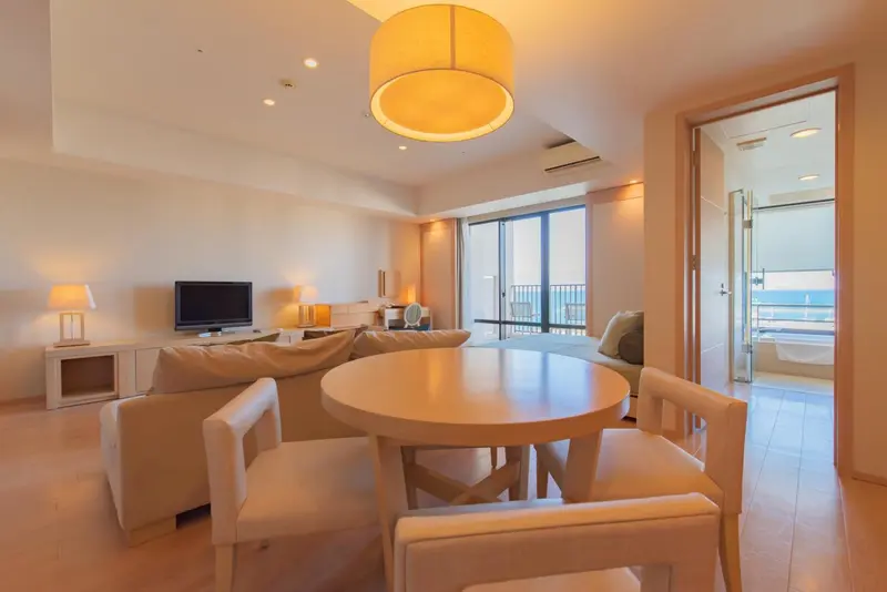 Un salon lumineux avec un coin repas et une vue sur la mer.