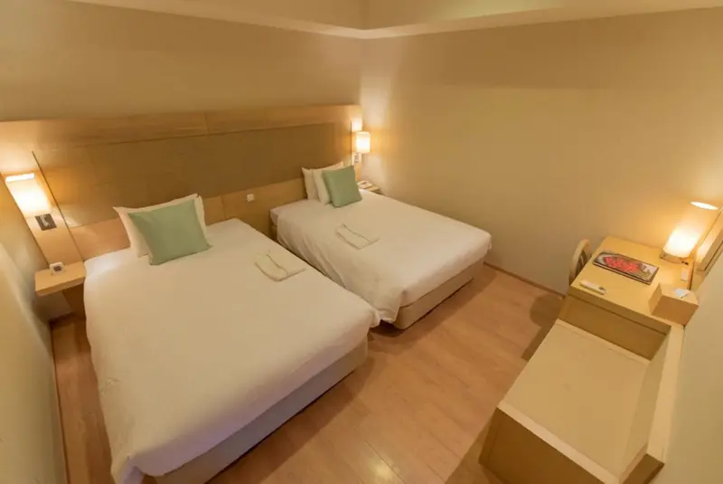 Une chambre avec deux lits simples et des tables de chevet.