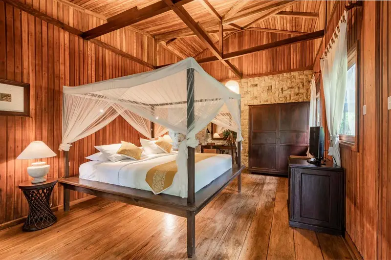 Une chambre avec un lit à baldaquin et une décoration en bois.