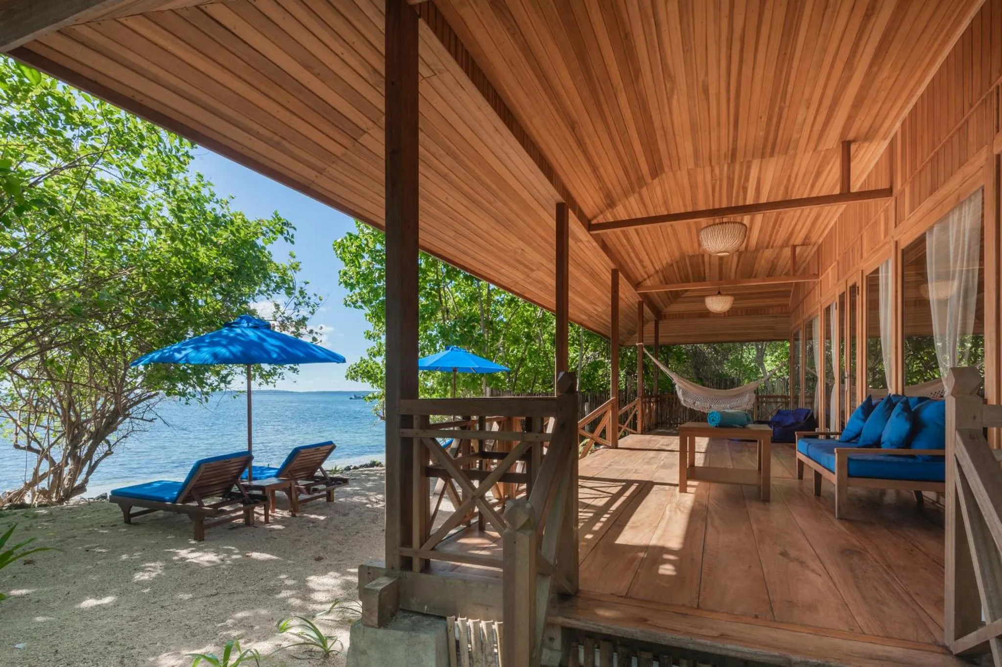 Terrasse en bois avec mobilier de détente face à la mer.