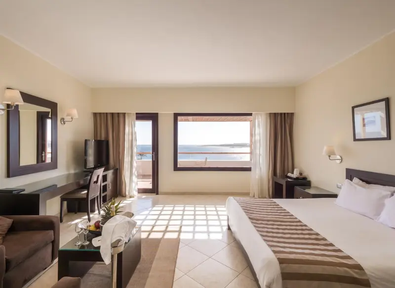 Une chambre lumineuse avec un lit et une vue sur la mer.