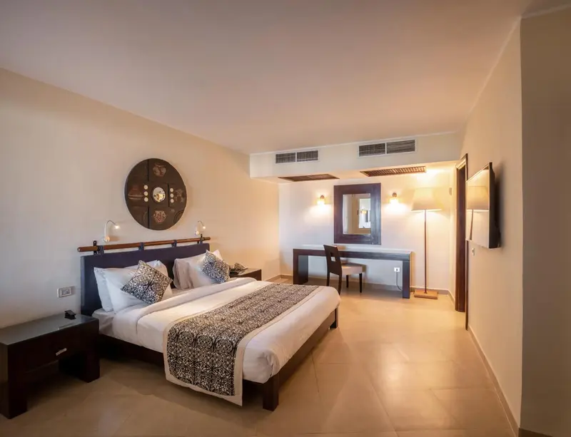 Une chambre d'hôtel lumineuse avec un grand lit et un bureau.