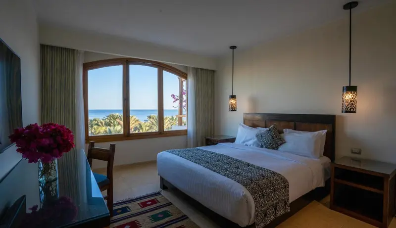 Une chambre lumineuse avec un grand lit et une vue sur la mer.