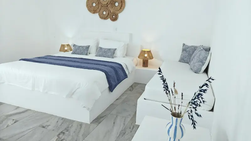 Une chambre lumineuse avec deux lits et une décoration sobre.