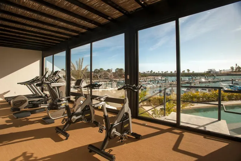 Une salle de sport lumineuse donne sur un port de plaisance.
