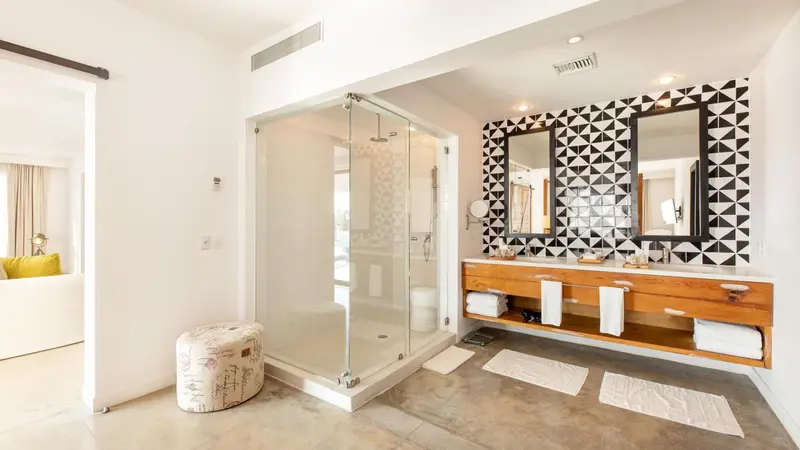 Une salle de bain moderne avec une douche vitrée et un meuble double vasque.
