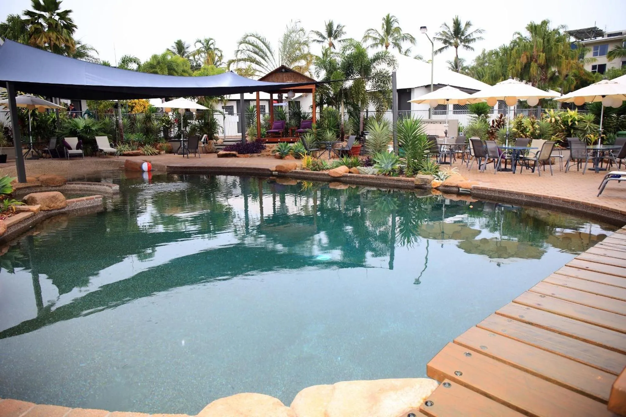 Une piscine bordée d'une terrasse avec des transats et des parasols.