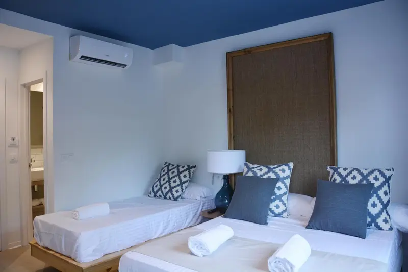 Une chambre lumineuse avec deux lits simples et une décoration sobre.