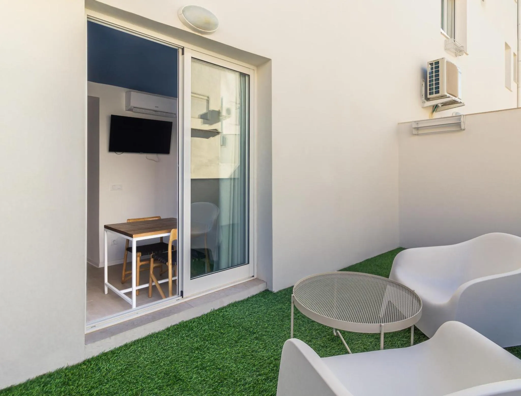 Terrasse avec mobilier d'extérieur et espace repas intérieur.